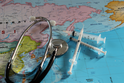 stethoscope and needles on top of world map