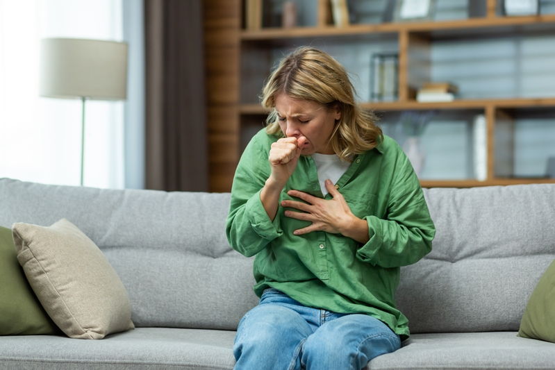 woman coughing and holding her chest
